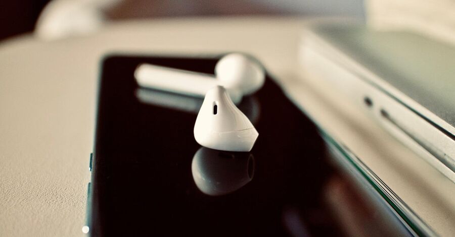 auriculares inalámbricos sobre un celular en un escritorio